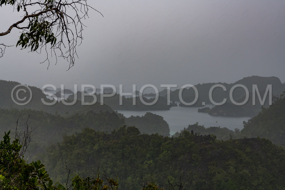 Photo de East Misool - groupe de petites îles dans un lagon bleu peu profond sous la pluie - Raja Ampat - Papouasie occidentale - Indonésie