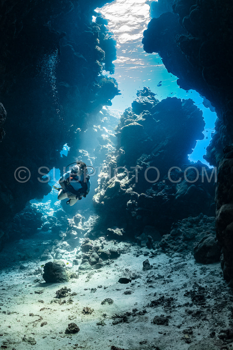 Photo de Femme plongeuse visitant une grotte sous-marine dans la mer rouge - Égypte - Shaab Claude